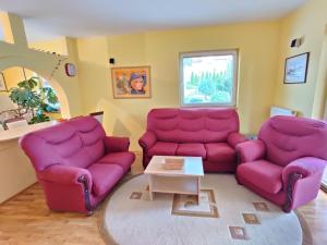 una sala de estar con 2 sofás morados y una mesa. en Villa Dama & Dubravka, en Zlatibor