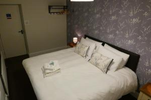 1 dormitorio con 1 cama con sábanas y almohadas blancas en The Victoria en Malham