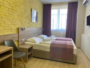 um quarto com uma cama, uma secretária e uma cadeira em Art хостел-готель "Адреналін" em Lutsʼk
