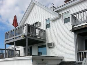 a large white house with a deck on it at Windrifter Resort in Wolfeboro
