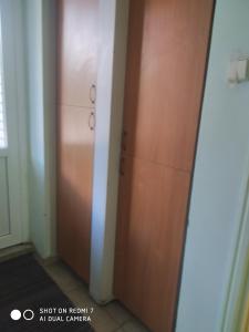 um armário com uma porta de madeira num quarto em Valjotė em Tauragė