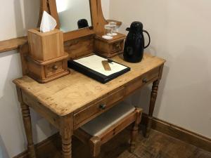 a wooden table with a mirror and a vase on it at Sebastians in Oswestry