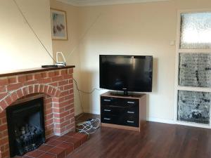 a living room with a tv and a fireplace at Thornley Avenue in Billingham