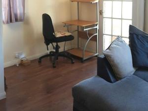 een woonkamer met een bureau, een stoel en een bank bij Thornley Avenue in Billingham