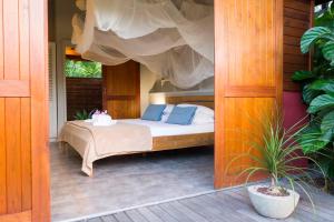 a bed with blue pillows on a porch at Shambala Lodge in Le Moule