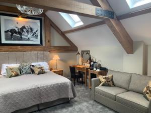 a bedroom with a bed and a couch and a desk at The Wheatsheaf Hotel, Sandbach in Sandbach