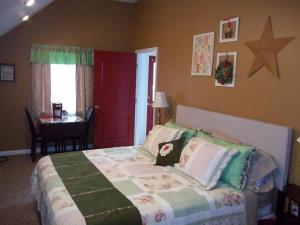 Tin Brook Bed & Breakfast في Walden: غرفة نوم بسرير مع باب احمر وطاولة