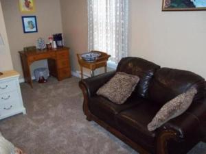 sala de estar con sofá de cuero y escritorio en Tin Brook Bed & Breakfast, en Walden