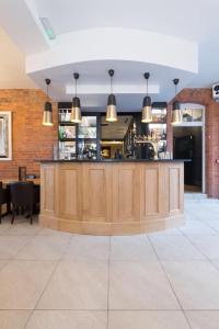 a restaurant with a bar in the middle of a room at The Wheatsheaf Hotel, Sandbach in Sandbach