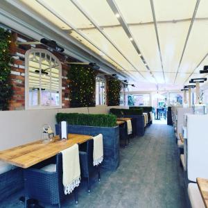 a restaurant with tables and chairs and a brick wall at The Wheatsheaf Hotel, Sandbach in Sandbach