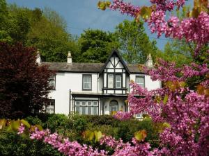 una casa con flores rosas delante de ella en Tintern Old Rectory, en Tintern