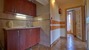 a kitchen with wooden cabinets and a tile floor at Dom Wczasowy Stanislawa in Biały Dunajec