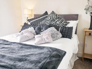 een bed met zwarte en witte kussens erop bij Tower View in Blackburn