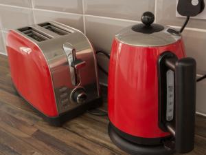 a red toaster next to a toaster on a counter at Townhouse PLUS @ Westminster Street Crewe in Crewe