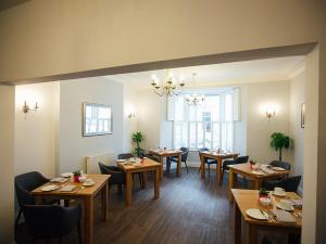 una sala da pranzo con tavoli e sedie in legno di The Townhouse a Tenby