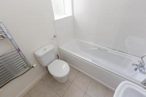 a bathroom with a toilet and a tub and a sink at Budget Rooms @ Underwood Lane Crewe in Crewe