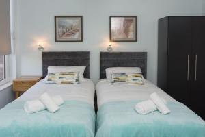um quarto com duas camas com almofadas em Titanic Guest Boutique, 4-Star Accommodation em Belfast