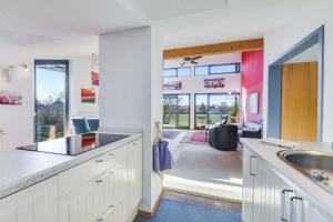 a kitchen with white cabinets and a sink and a living room at Muc City de Lux 120 qm in Munich