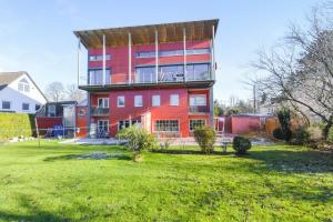 a large red building with a yard in front of it at Muc City de Lux 120 qm in Munich