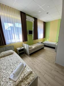 um quarto de hotel com duas camas e um sofá em Art хостел-готель "Адреналін" em Lutsʼk