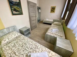 um quarto com duas camas e um banco em Art хостел-готель "Адреналін" em Lutsʼk