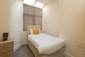 a small bedroom with a bed and a window at Townhouse @ Electricity Street Crewe in Crewe
