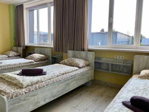 duas camas num quarto com duas janelas em Art хостел-готель "Адреналін" em Lutsʼk