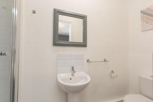 a white bathroom with a sink and a mirror at Crewe Rooms Brooklyn Street in Crewe