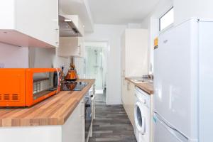 una cocina con un aparato naranja en la encimera en Townhouse @ 76 Clare Street Stoke en Stoke on Trent