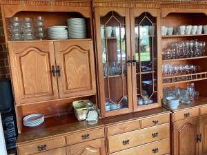 a wooden cabinet with plates and dishes in it at Éden Fonyód in Fonyód