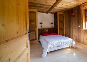 sypialnia z łóżkiem w drewnianym domku w obiekcie Gîte Balnéo Au Coeur des Alpes w mieście Taninges