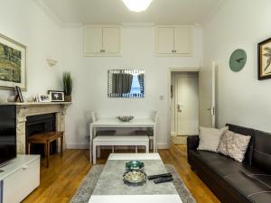 a living room with a couch and a table at Spacious 1 Bed in West Kensington or Hammersmith in London