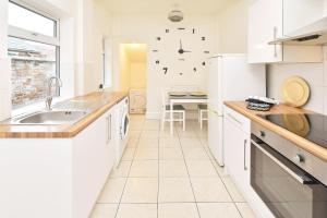 a white kitchen with a sink and a counter at Townhouse @ Earle Street Crewe in Crewe