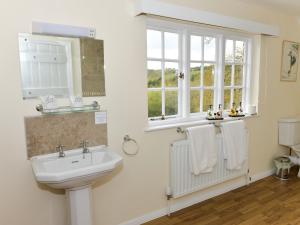 a bathroom with a sink and a window and towels at Twyford Farm B&B in Haywards Heath