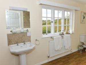 y baño con lavabo, ventana y toallas. en Twyford Farm B&B, en Haywards Heath