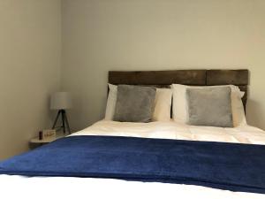 a bedroom with a bed with a blue blanket on it at Sapphire House Sasco Apartments in Blackpool