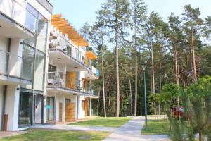 an exterior view of a building with trees in the background at Apartament Mariva B106 z balkonem - Pobierowo - przy samym morzu - obiekt Euronia in Pobierowo