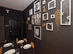 a dining room with a black wall with pictures at Townhouse PLUS @ 301 West Street Crewe in Crewe