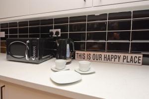 a kitchen counter with two cups and a coffee maker at Townhouse PLUS @ 301 West Street Crewe in Crewe