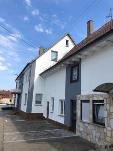 uma casa branca com um edifício de pedra em My Pension STUTTGART-AIRPORT-MESSE em Leinfelden-Echterdingen