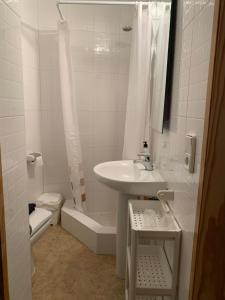 y baño blanco con lavabo y ducha. en Hostal Casa Michaels, en Móra d'Ebre