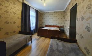 sypialnia z 2 łóżkami i oknem w obiekcie Racha guest house MERO w mieście Ambrolauri