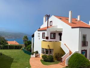a white house with a stairway to a yard at Top villa with extraordinary view of Atlantic in São Martinho do Porto