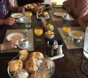 un grupo de personas sentadas alrededor de una mesa con comida para el desayuno en Casa Águas Mansas, en Cadima