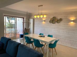 a dining room with a white table and blue chairs at Top villa with extraordinary view of Atlantic in São Martinho do Porto