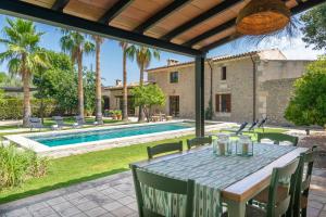 un patio con mesa y sillas y una piscina en S'Hort Des Capellà Verona en Selva