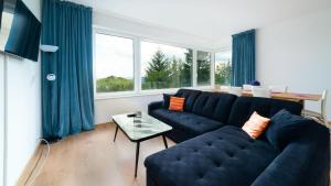 a living room with a blue couch and a table at Apartamenty EverySky - Wyspiańskiego 4-4a in Karpacz