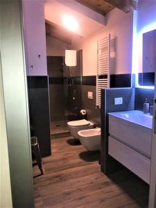 a bathroom with two toilets and two sinks at Residenza del Borgo in Bergamo