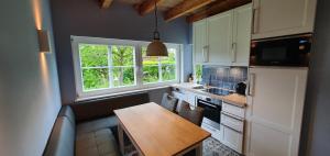 eine kleine Küche mit einem Tisch und einem Fenster in der Unterkunft Ostseehaus Heisterbusch in Kellenhusen