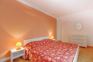 sypialnia z czerwonym łóżkiem i 2 lampami w obiekcie Ursula w miejscowości Mali Lošinj